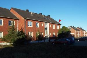 une maison en briques rouges avec une voiture garée devant elle dans l'établissement Ferienwohnung Berliner Ring, à Hörnum