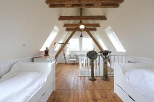 Schlafzimmer im Dachgeschoss mit 2 Betten und einem Ventilator in der Unterkunft Dünenhaus in Hörnum