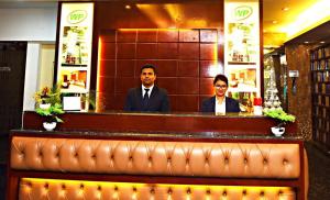 um homem e uma mulher sentados num bar em West Park Inn em Daca