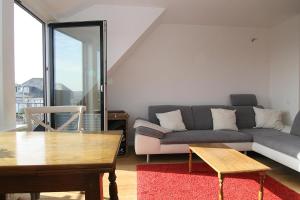 ein Wohnzimmer mit einem Sofa und einem Tisch in der Unterkunft Ferienwohnung Dünennest in Hörnum