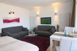 ein Wohnzimmer mit 2 Sofas, einem Bett und einem Tisch in der Unterkunft Ferienwohnung Ferlings in Hörnum