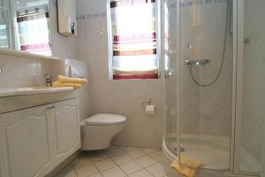 ein Bad mit einer Dusche, einem WC und einem Waschbecken in der Unterkunft Ferienwohnung Ferlings in Hörnum
