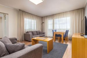 - un salon avec un canapé et une table dans l'établissement Adelle Apartments Viru Keskuses, 9-th floor, à Tallinn