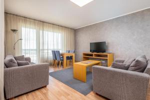 a living room with two couches and a television at Adelle Apartments Viru Keskuses, 9-th floor in Tallinn