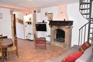 a living room with a fireplace and a tv at Il giardino di Adele in Sermoneta