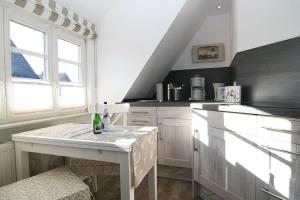 a kitchen with a white island in a room at Ferienwohnung Claßen in Hörnum