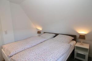 ヘルヌムにあるFerienwohnung Claßenのベッドルーム1室(ベッド2台、ランプ2つ付)