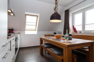 ヘルヌムにあるHaus Emilia - Appartement Leuchtturmのキッチン(木製テーブル付)が備わります。一部の窓があります。