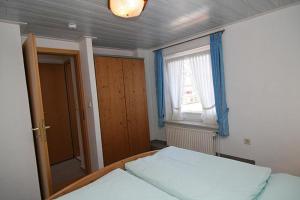 a bedroom with a bed and a window and a mirror at Haus Gräpel App 2 in Hörnum