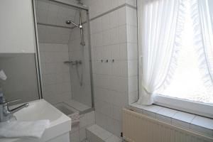 a bathroom with a shower and a sink and a window at Haus Gräpel App 2 in Hörnum +2 photos
