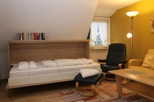 a bedroom with a bed and a desk and a chair at Haus Gräpel App 3 in Hörnum