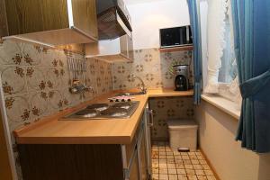 a small kitchen with a stove and a sink at Haus Gräpel App 3 in Hörnum +4 photos