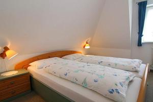 ヘルヌムにあるHaus Gräpel App 4のベッドルーム1室(ベッド2台、テーブル、窓付)