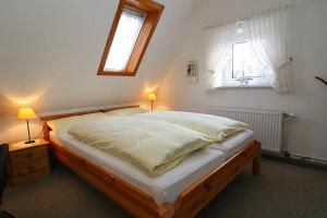 ヘルヌムにあるHaus Gräpel App 5のベッドルーム1室(ランプ2つ、窓付)