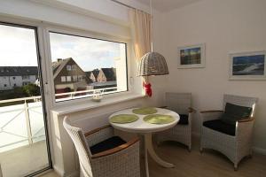 ヘルヌムにあるHaus Möwe Wohnung Gonnermannのテーブルと椅子、窓が備わる客室です。