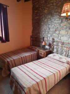 two beds in a room with a stone wall at Apartamentos Farrai llova 
