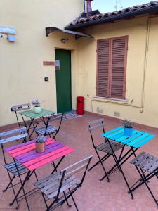 - un ensemble de tables et de chaises sur une terrasse dans l'établissement R&B La Pomposa dei Motori, à Modène