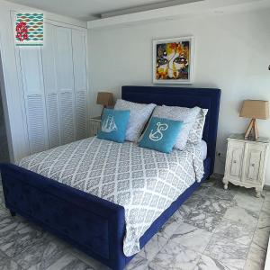 1 dormitorio con cama azul y almohadas azules en Hermosos Apartamentos Frente Al Mar, en San Andrés