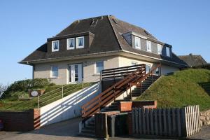 ein Haus auf einem Hügel mit einer Treppe in der Unterkunft Hüs Auert Tharep, Wohnung 2 in Hörnum