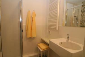 a white bathroom with a sink and a shower at Wohnung Mayer in Hörnum