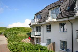 a large white house with windows and bushes at Ferienwohnung Frahm in Hörnum