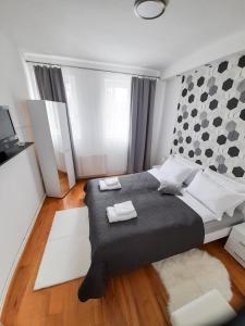 een slaapkamer met een groot bed en 2 handdoeken bij Apartman Djoana - dvosoban apartman u blizini Akva Parka Vrnjačke Terme in Vrnjačka Banja