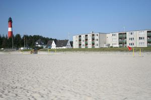 a beach with a lighthouse and some volleyball nets at Lord Nelson in Hörnum