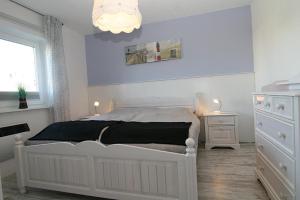 ヘルヌムにあるLüddn Traumの白いベッドルーム(白いベッド1台、窓付)