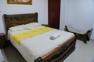 a bedroom with a large bed with a wooden headboard at Hotel Las Vegas RB in Ríohacha