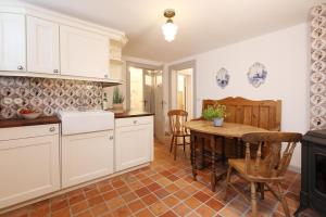 a kitchen with white cabinets and a table and chairs at Pesel in Hörnum