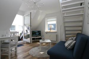 a living room with a staircase and a blue couch at Seaside 4 in Hörnum