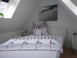a bedroom with a white bed with two dolphins on it at Seaside 4 in Hörnum