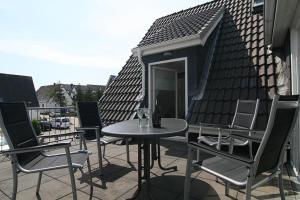 a patio with a table and chairs on a roof at Seaside 4 in Hörnum