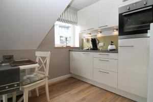 a kitchen with white cabinets and a counter top at Strandperle 03 in Hörnum
