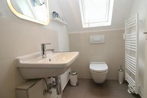 a bathroom with a sink and a toilet at Strandperle 03 in Hörnum +7 photos