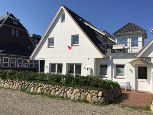 a white house with a red arrow on it at Strandperle 03 in Hörnum