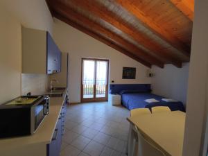 una cocina y un dormitorio con una cama en una habitación en Residenza Arcobaleno, en Tenno
