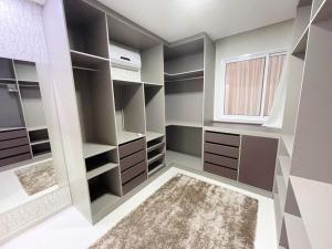 a walk in closet with gray walls and a window at SCHULZ Turtles Home in Guarapari