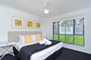 Un dormitorio con una cama grande y una ventana en Sentosa on Tugun - Beachfront 5 Bedroom en Gold Coast
