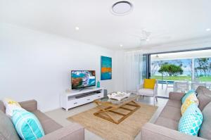 sala de estar con sofá y TV en Sentosa on Tugun - Beachfront 5 Bedroom, en Gold Coast