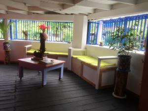 a room with a bench and a table and windows at The Hill B&B (El Morro Hosteria) in El Valle