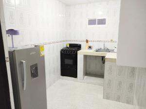 a kitchen with a stove and a refrigerator at Apartamentos Riohacha in Ríohacha