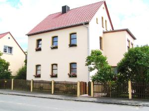 a white house with a fence at Ferienwohnung3 Grimma in Grimma