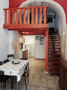 a living room with a table and a staircase at porta marina ortigia in Siracusa