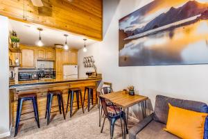 a living room with a kitchen and a bar with stools at The Lake House in Shaver Lake