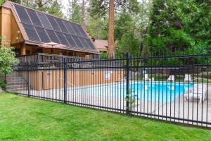 a black fence in front of a swimming pool with solar panels at The Lake House in Shaver Lake