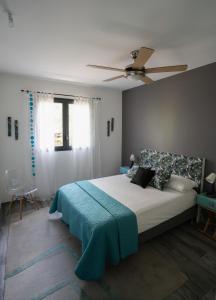 a bedroom with a bed and a ceiling fan at Rhum Cahuette T3 climatisé in Manapany-les Bains