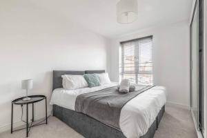 a bedroom with a large bed and a window at 2 BED & 2 BATH COSY APARTMENT SLOUGH- FREE PARKING in Slough