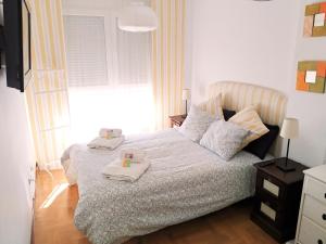een slaapkamer met een bed met twee handdoeken erop bij El Duplex Luanquino in Luanco