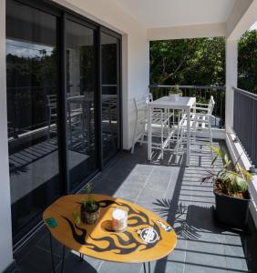 un patio con tavolo e sedie sul balcone. di Rhum Cahuette T3 climatisé a Manapany-les Bains